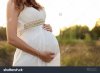 stock-photo-pregnant-girl-in-a-white-dress-at-months-pregnant-340858928.jpg