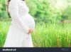 stock-photo-pregnant-woman-carry-her-belly-with-love-and-care-in-fresh-garden-474947473.jpg